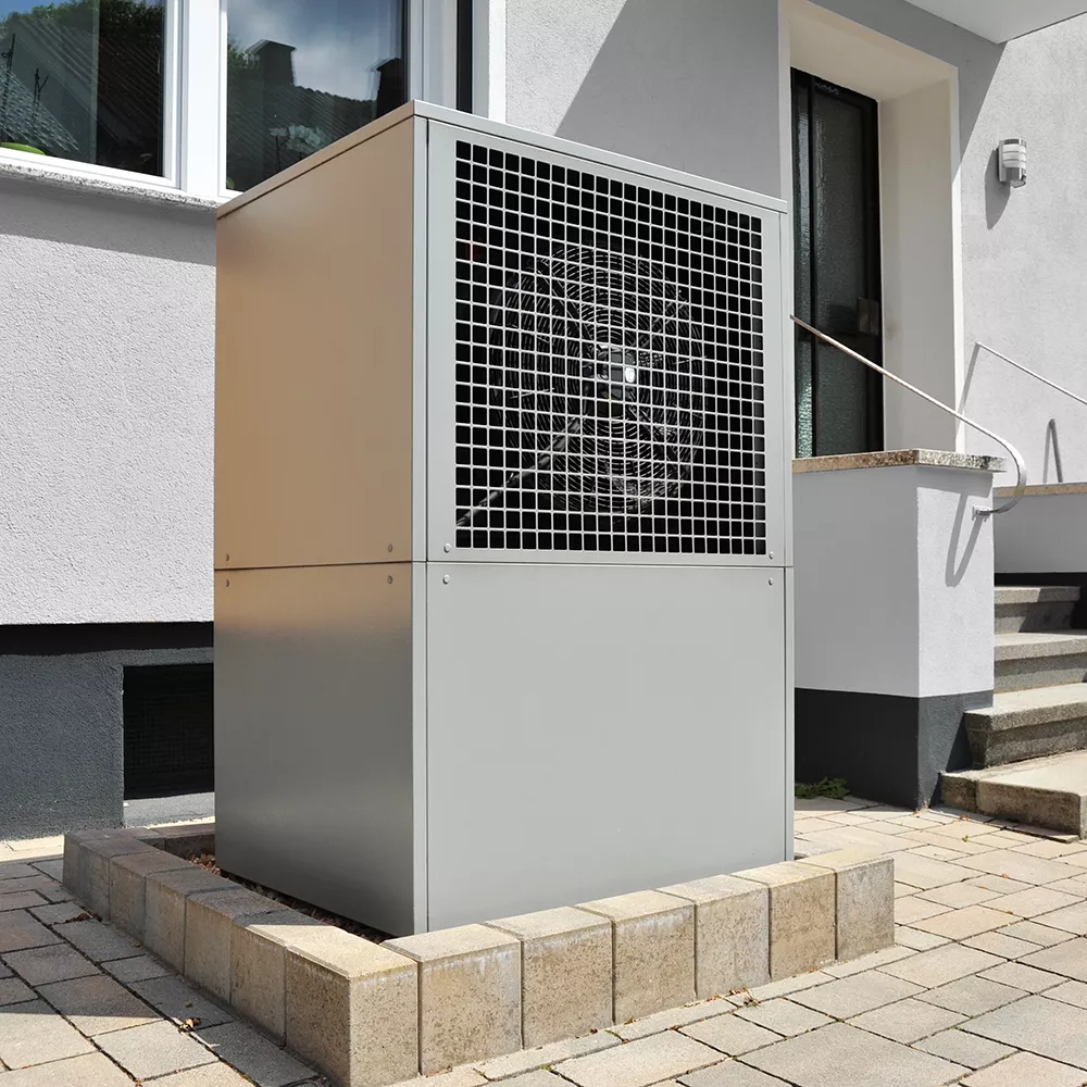 Air source heat pump in front of a house